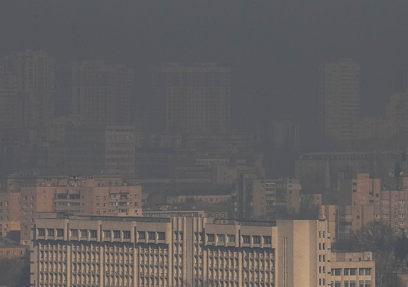 Residential buildings in Kyiv are seen through smoke from fires after shelling nearby