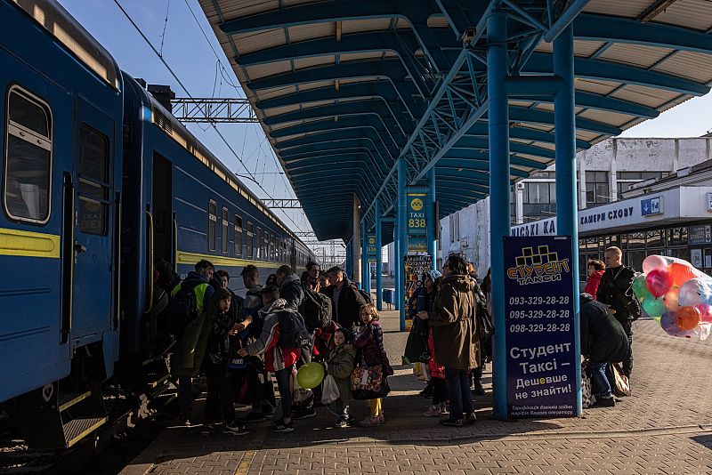 Niños huérfanos que huyeron de la ciudad ucraniana de Polohi, ocupada por el ejército ruso, suben con sus profesores a un tren de evacuación hacia la parte occidental de Ucrania, en la estación de tren de Zaporiyia, en el sureste de Ucrania.