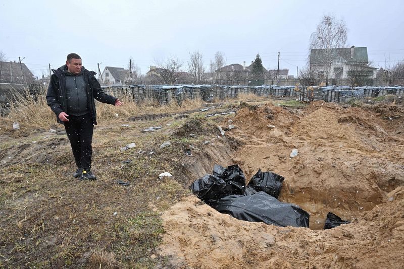 Un hombre señala una fosa común en la ciudad de Bucha, al noroeste de la capital ucraniana, Kiev.