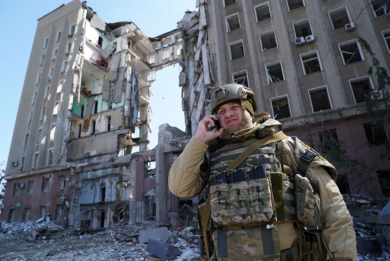 Un soldado ucraniano frente a un edificio que ha sido bombardeado por el Ejército ruso.