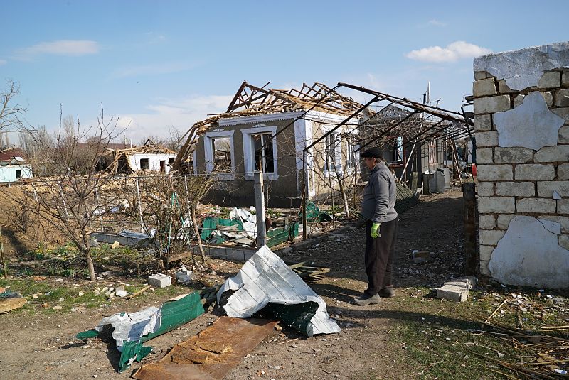 Un hombre recoge los destrozos del ataque ruso en la localidad rural de Bashtanka.