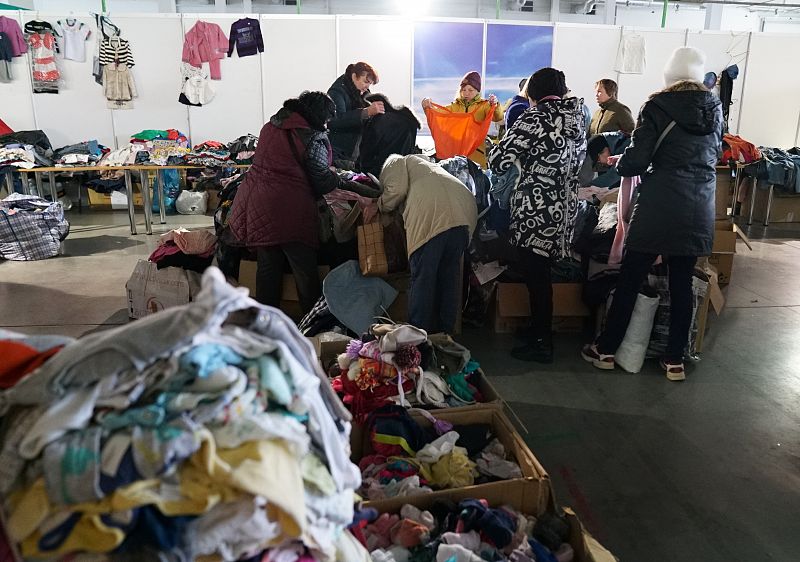 Varias mujeres buscan ropa en un centro de apoyo a los refugiados en Zaporiyia.