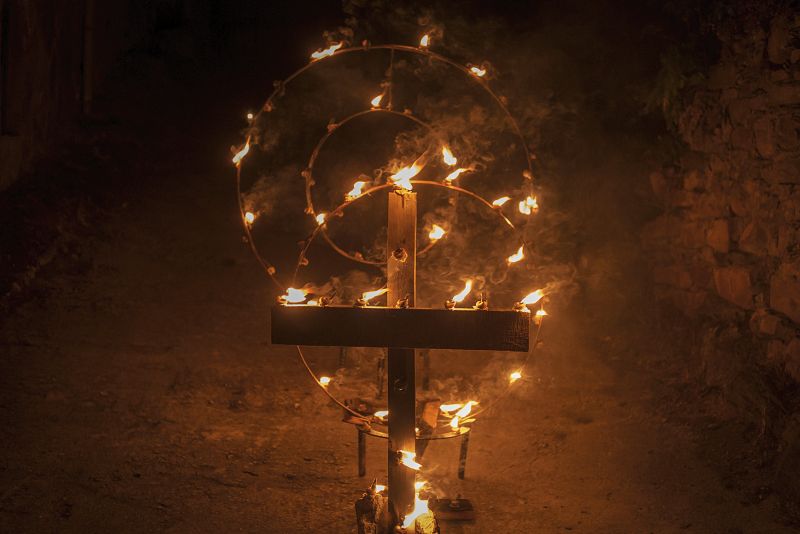 Detalle de una cruz y caracoles ardiendo durante la celebración de la procesión de La Dolorosa, más conocida como la de los Caracoles, en la localidad orensana de O Castro