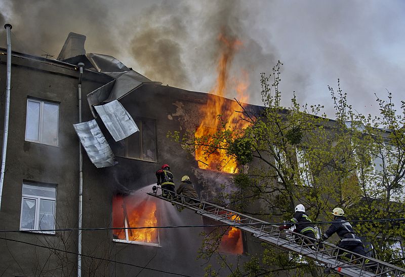 Los bomberos intentan apagar un incendio en un edificio tras un bomberdeo ruso