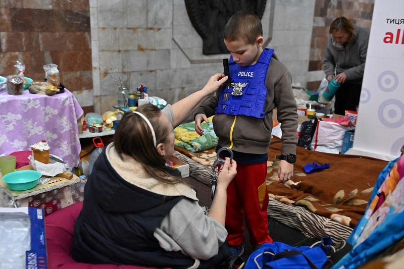 Una mujer habla con un niño mientras se refugian en una estación de metro en las afueras de la ciudad de Járkov.