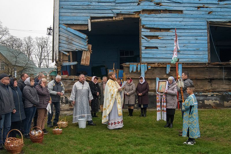 Un sacerdote dirige el servicio ortodoxo de Pascua junto a la Iglesia de la Natividad de la Santa Virgen, dañada por los bombardeos, en el pueblo de Peremoha, en la región de Kiev.