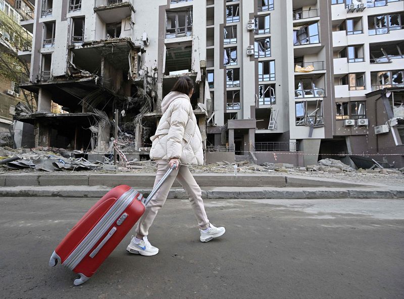 Una mujer pasa por delante de un edificio dañado en Kiev, en medio de la invasión rusa de Ucrania.