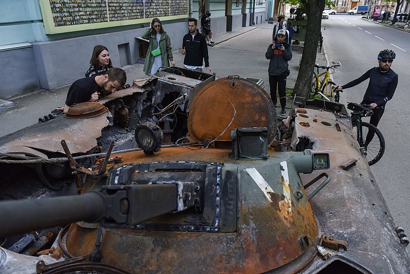 Un grupo de personas observa un vehículo blindado de transporte de tropas (APC) ruso destruido, expuesto cerca del museo de la guerra en Kiev.