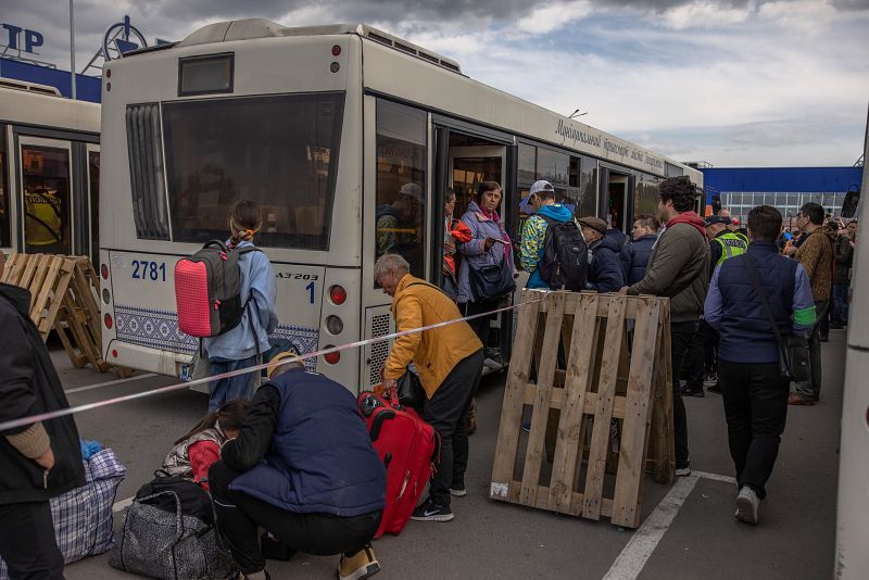 Las personas evacuadas de la planta siderúrgica Azovstal, de la ciudad de Mariúpol y de las zonas circundantes se reúnen tras llegar en cinco autobuses a Zaporiyia.