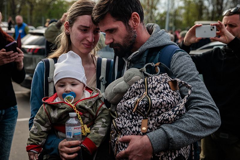 Un hombre recibe a su mujer y a su hijo, de 6 meses, tras llegar desde Mariúpol a una zona de registro y tramitación de desplazados internos en Zaporiyia.
