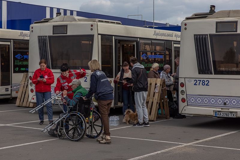 Las personas evacuadas de la planta siderúrgica Azovstal, de la ciudad de Mariúpol y de las zonas circundantes se reúnen tras llegar en autobuses al punto de evacuación, en Zaporiyia.