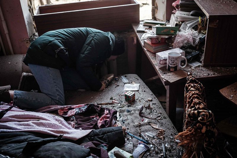 Una mujer recoge sus objetos personales de su hogar tras el bombardeo ruso