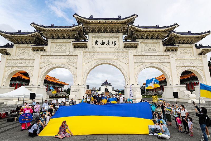 Manifestantes muestran pancartas y fotos de la guerra en La plaza de la Libertad, en Taipei, Taiwán. 