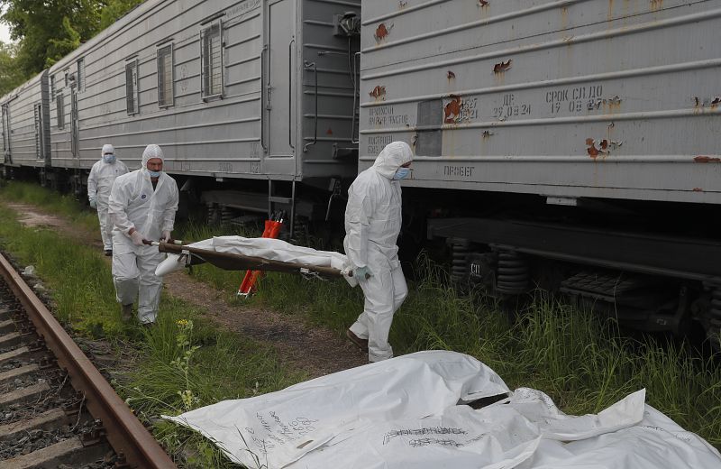 Soldados ucranianos descargan bolsas para cadáveres con soldados rusos antes de llevarlos a un vagón frigorífico en una estación de ferrocarril de Kiev