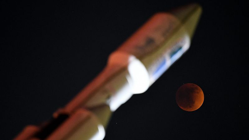 La luna de sangre, vista durante el eclipse lunar total junto al monumento iluminado del cohete SpaceX Falcon Heavy en Hawthorne, California.