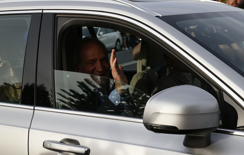 El rey Juan Carlos I saluda tras su llegada al aeropuerto