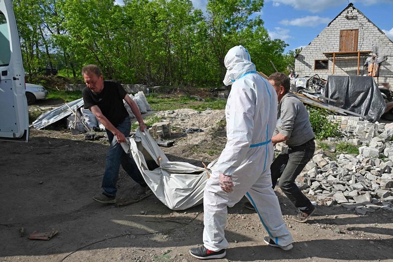 Residentes locales ayudan a un equipo forense de la policía ucraniana a exhumar cuerpos de soldados rusos, en el pueblo de Mala Rogan, cerca de Járkov.