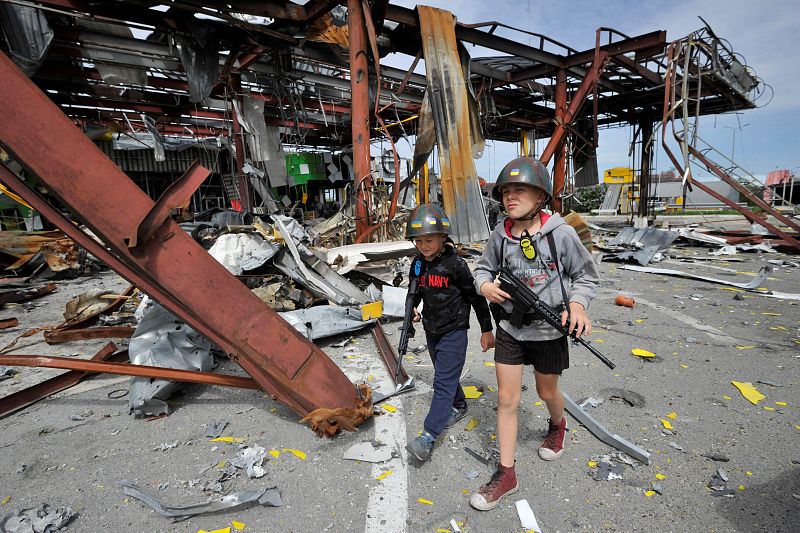 Niños ucranianos juegan a imitar a los combatientes de la defensa territorial que patrullan en el pueblo de Stoyanka, región de Kiev.