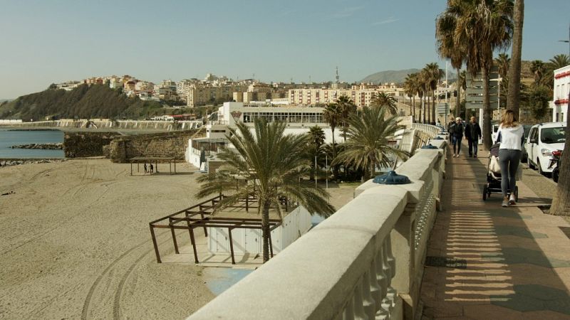 Una mujer paseando en el malecón de Ceuta