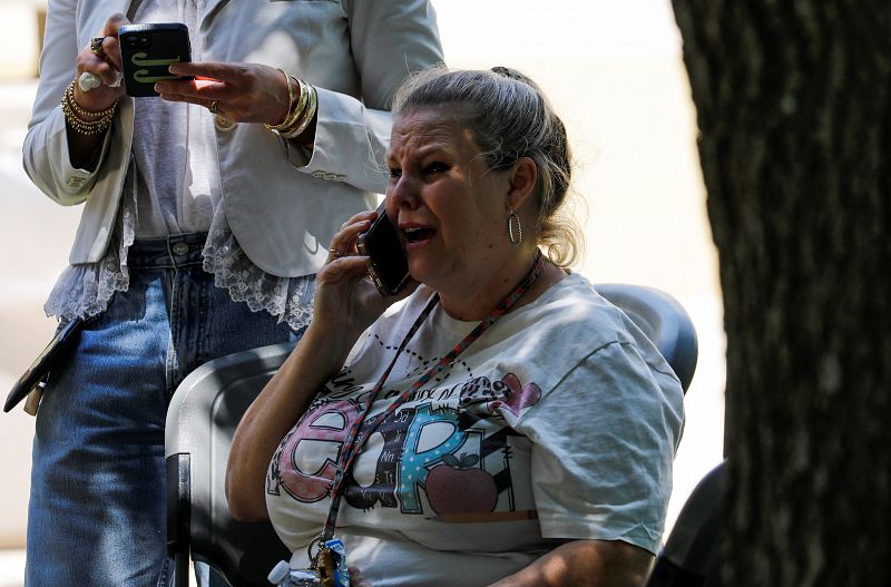 Una mujer habla por teléfono en el Centro Cívico Ssgt Willie de Leon, donde los estudiantes habían sido trasladados desde la Escuela Primaria Robb. 