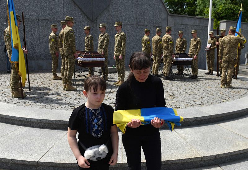 La viuda y la hija de Andriy Vertiev, militar ucraniano, asesinado durante la invasión rusa de Ucrania, reaccionan durante el funeral en el cementerio de Lychakiv, en la ciudad occidental ucraniana de Leópolis