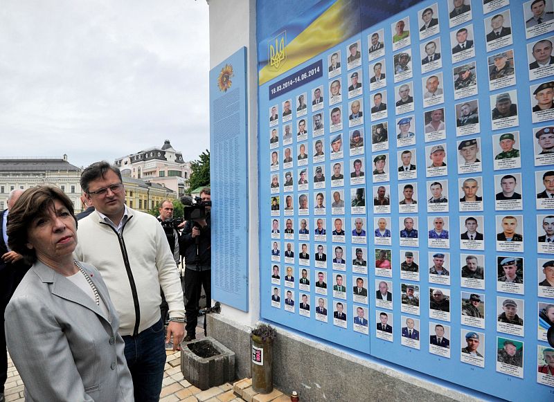 El ministro de Asuntos Exteriores ucraniano, Dmytro Kuleba (d), y la ministra de Asuntos Exteriores francesa, Catherine Colonna, asisten a una ceremonia en el muro conmemorativo de los militares ucranianos muertos durante la ocupación rusa en Kiev.