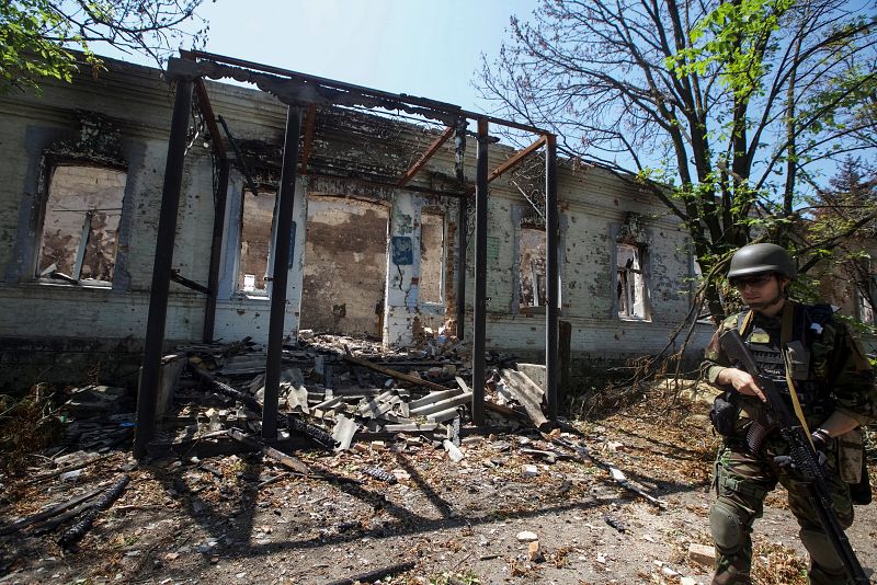 Un agente de policía comprueba una zona durante la evacuación de los residentes locales entre bombardeos, en medio del ataque de Rusia a Ucrania, en el pueblo de Novomykhailivka, en la región de Donetsk