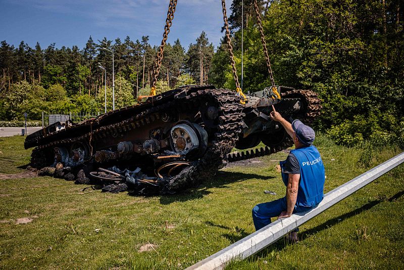 Un trabajador controla la retirada de un tanque ruso destruido cerca del pueblo de Stoyanka, a las afueras de Kiev.