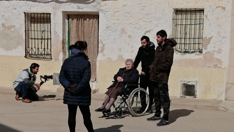 El cámara graba a los agricultores jóvenes que sacan a pasear a Juliana, de 94 años, que va en silla de ruedas,