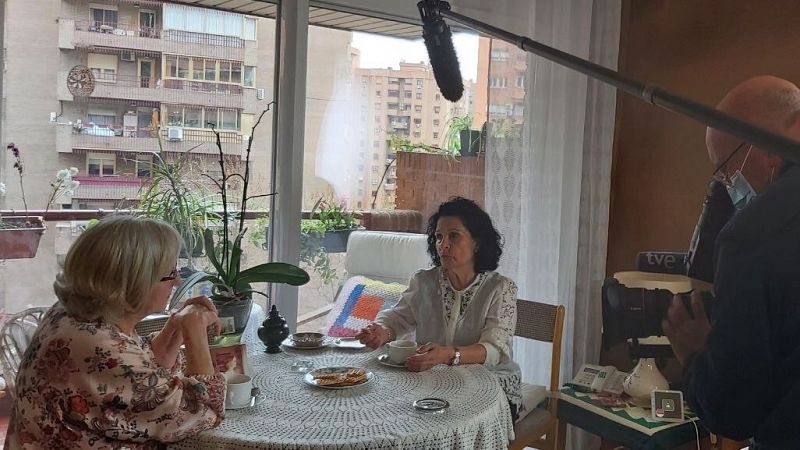 Paz y su vecina, María Jesús, en una mesa camilla toman café