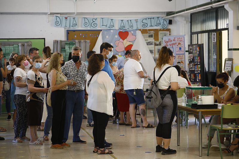 Colas de personas esperan para introducir en la urna su papeleta de voto en un colegio de Córdoba