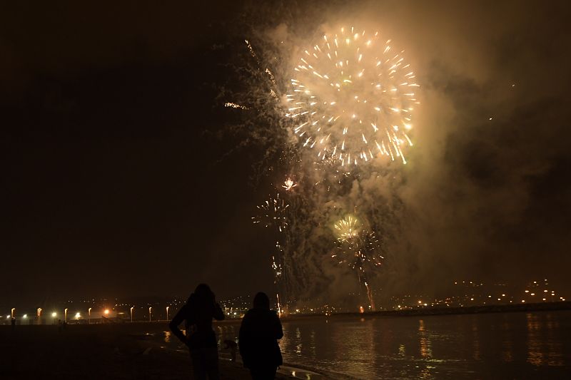 Los fuegos artificiales iluminan la playa de Poniente durante la celebración de la Noche de San Juan en Gijón.