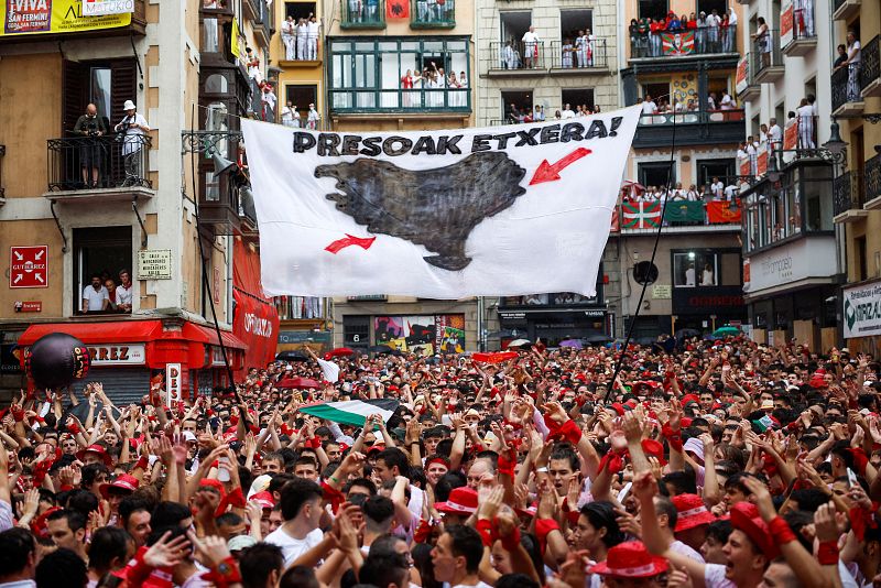 Una pancarta que dice "Presos a casa" cuelga sobre la plaza del Ayuntamiento de Pamplona durante la inauguración de las fiestas de San Fermín