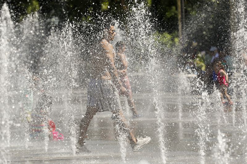 En la imagen, niños y adultos se refrescan en las fuentes del Parque Central de Valencia.