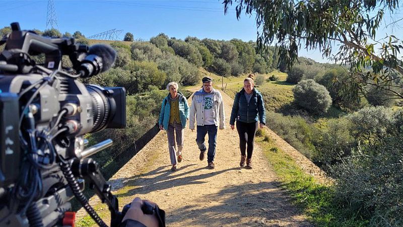 Tres miembros de Ecologistas en Acción atraviesan a pie un puente en Aznalcóllar para ir a la mina
