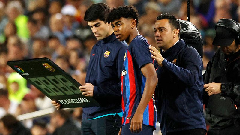 El entrenador del Barcelona Xavi Hernández da instrucciones a Lamine Yamal antes de entrar al campo