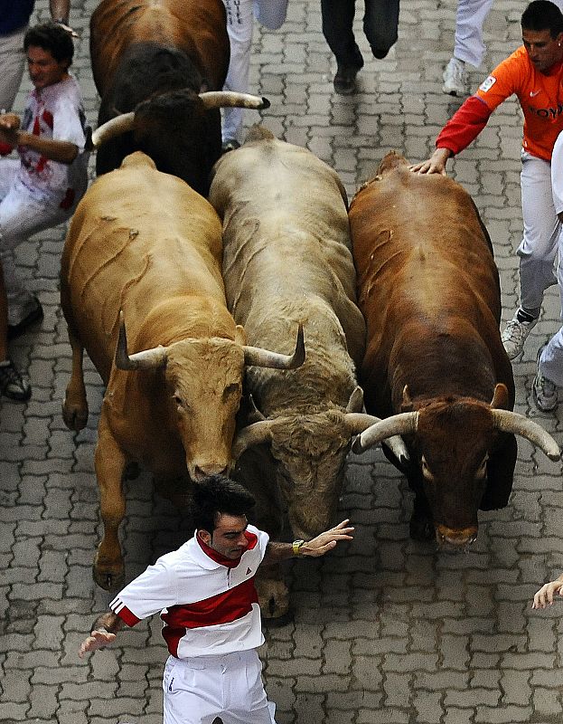 Runners are chased by Nunez del Cuvillo ranch bulls during the last bull run of the San Fermin festival in Pamplona