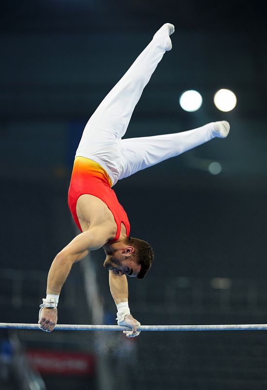 El gimnasta del equipo español Manuel Carballo realiza su ejercicio de barra.