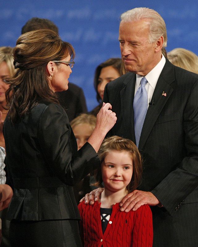 El senador Biden habla con Palin mientras tiene un gesto cariñoso con la hija de su rival