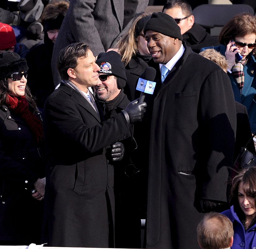 El ex jugador de baloncesto de la NBA Magic Johnson conversa con un periodista en la grada desde donde presenciará el acto de investidura de Barak Obama.