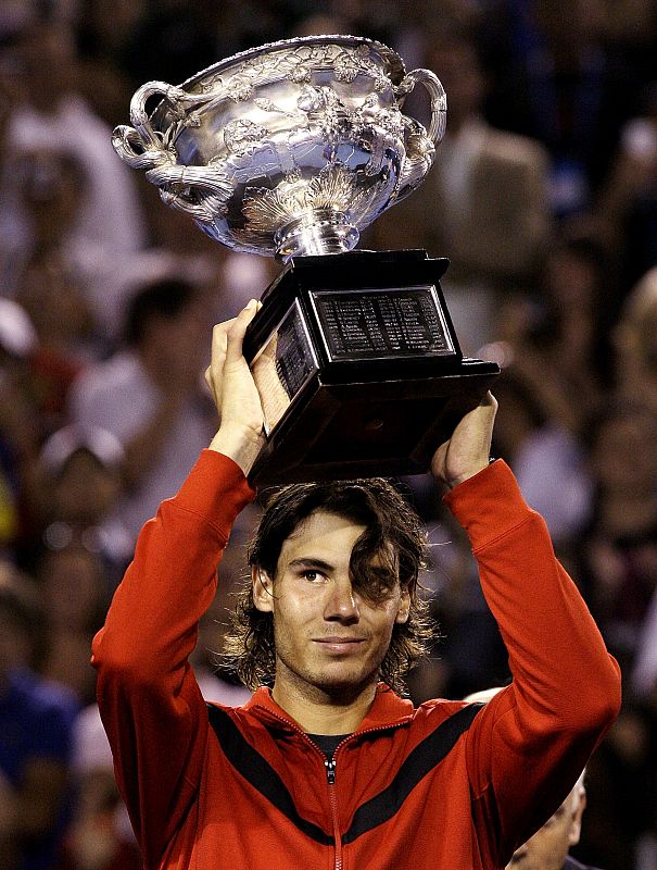 Spain's Nadal holds up the trophy after winning his men's singles final match against Switzerland's Federer at the Australian Open