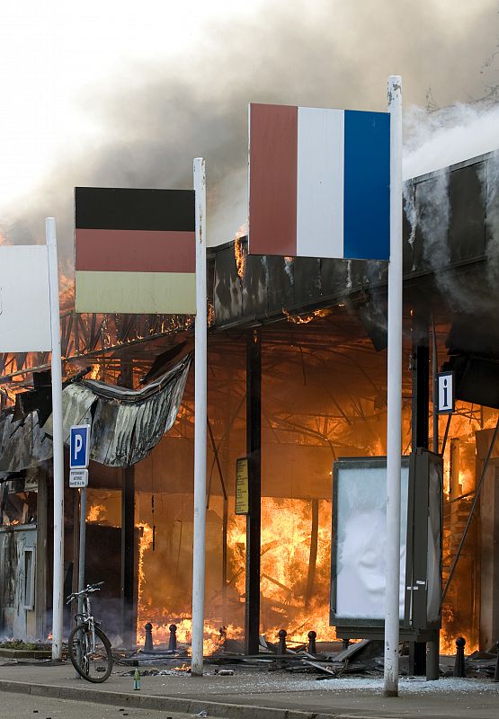 A burning super market at the French-German border crossing  is pictured during anti-NATO demonstrations in Strasbourg