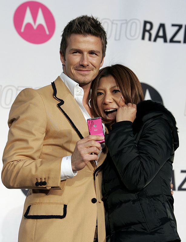 Soccer player Beckham poses with Japanese fan at promotional event in Tokyo