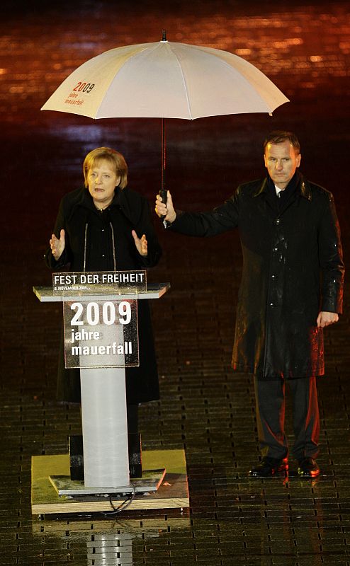 German Chancellor Angela Merkel (L) makes a speech at the Brandenburg Gate in Berlin