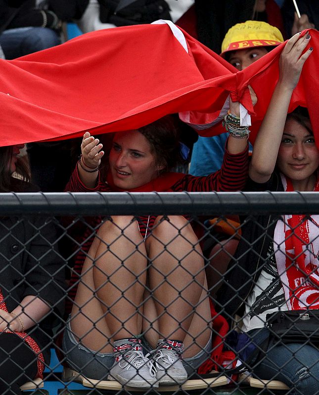 Varias espectadoras se protegen de la lluvia en el primer día de celebración del Abierto de Australia de tenis.