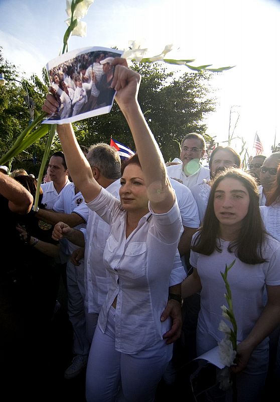 La cantante Gloria Estefan sostiene una fotografía de las Damas de Blanco de Cuba durante la marcha