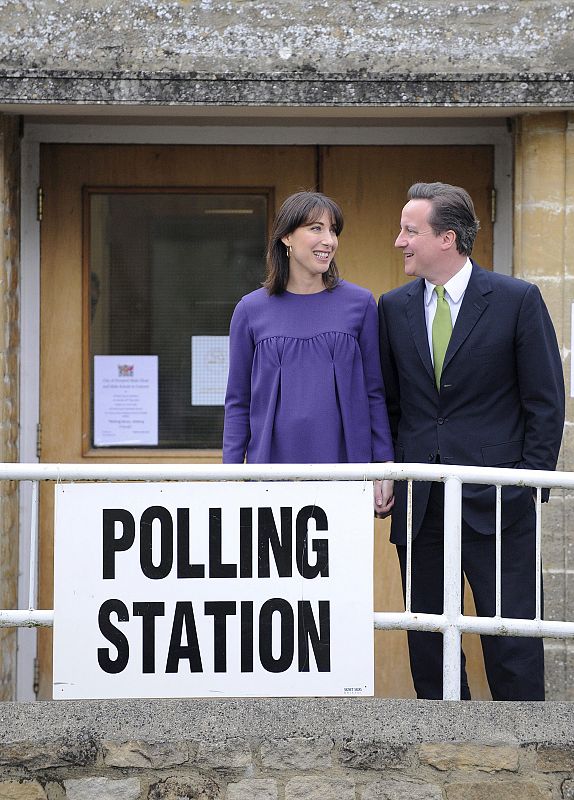 El candidato conservador, David Cameeron, y su mujer, Samantha, abandonan el colegio electoral cerca de Witney en Oxfordshire después de votar.