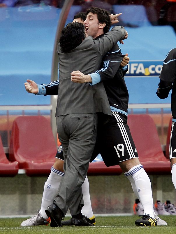 Argentina's coach Maradona celebrates the goal by Heinze (not pictured) with Milito during their 2010 World Cup Group B soccer match against Nigeria at Ellis Park stadium in Johannesburg