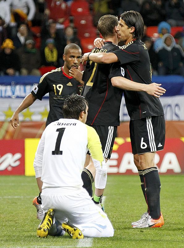 Germany's Jansen celebrates his goal with Khedira as Uruguay's goalkeeper Muslera reacts during the 2010 World Cup third place playoff soccer match