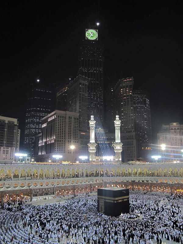 Muslim pilgrims pray inside the Grand Mosque, with the Mecca Clock lit up in the background, on the first day of the fasting month of Ramadan in Mecca